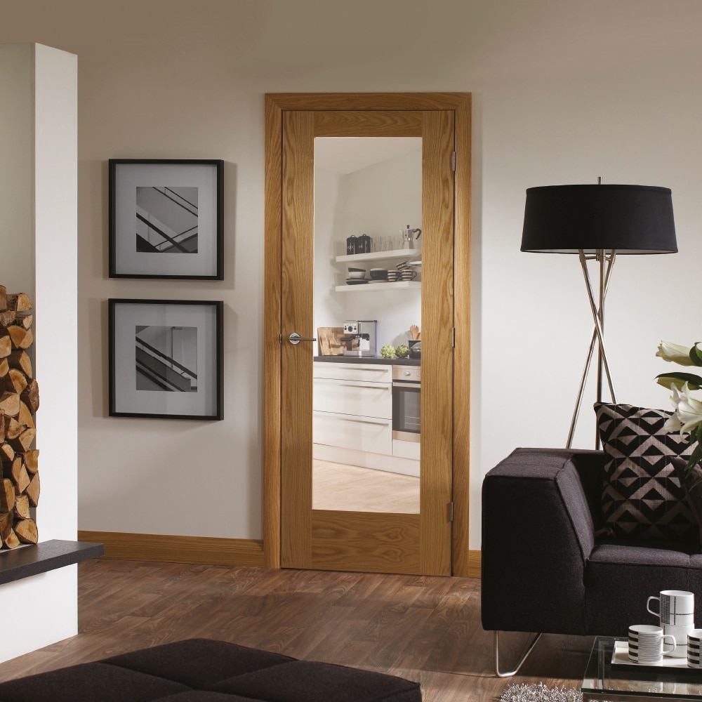 An Oak Pattern 10 Clear Glazed Door in a living room, showing the adjacent kitchen through the glass