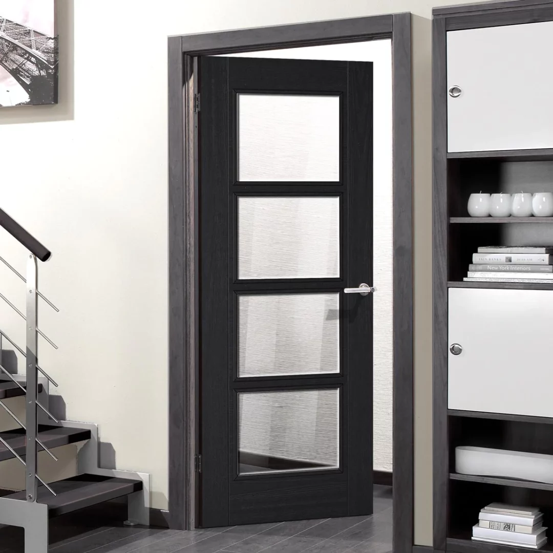 A charcoal black internal glazed 4 panel interior door showing hung in a hallway with a staircase visible