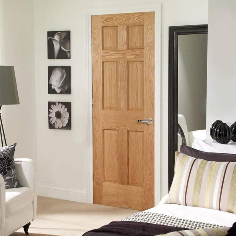 An Oak Wooden Internal 6 Panel Fire Door in a bedroom with a silver chrome handle